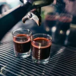 Two freshly brewed espresso shots pouring from a modern coffee machine in Nagpur, India.